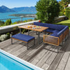 Patio dining set featuring acacia wood table and navy cushions, perfect for outdoor relaxation by the poolside.