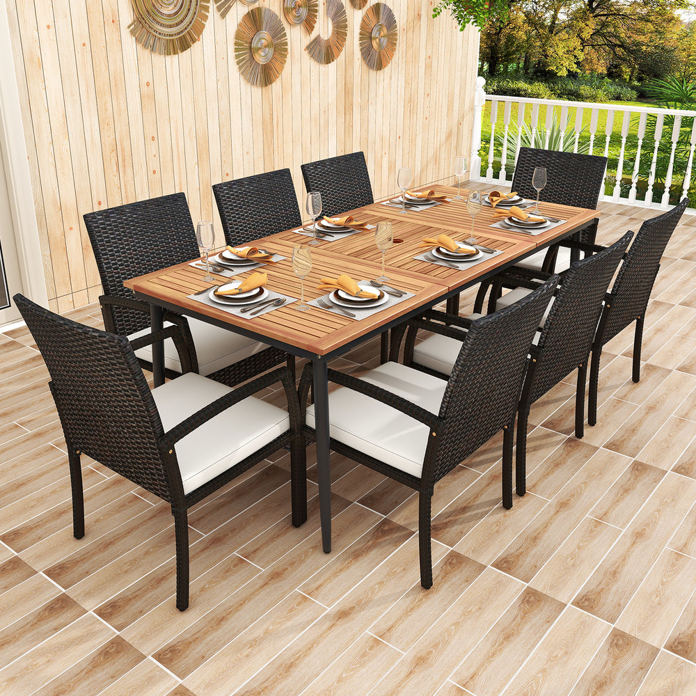 Rectangular patio dining table made of acacia wood with slatted design, surrounded by 8 rattan chairs with cushions for.
