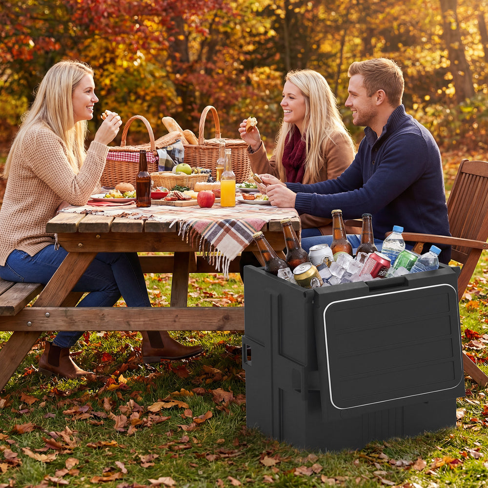 91 Qt insulated food pan carrier in black, shown with drinks and food at an outdoor picnic, ideal for parties and.