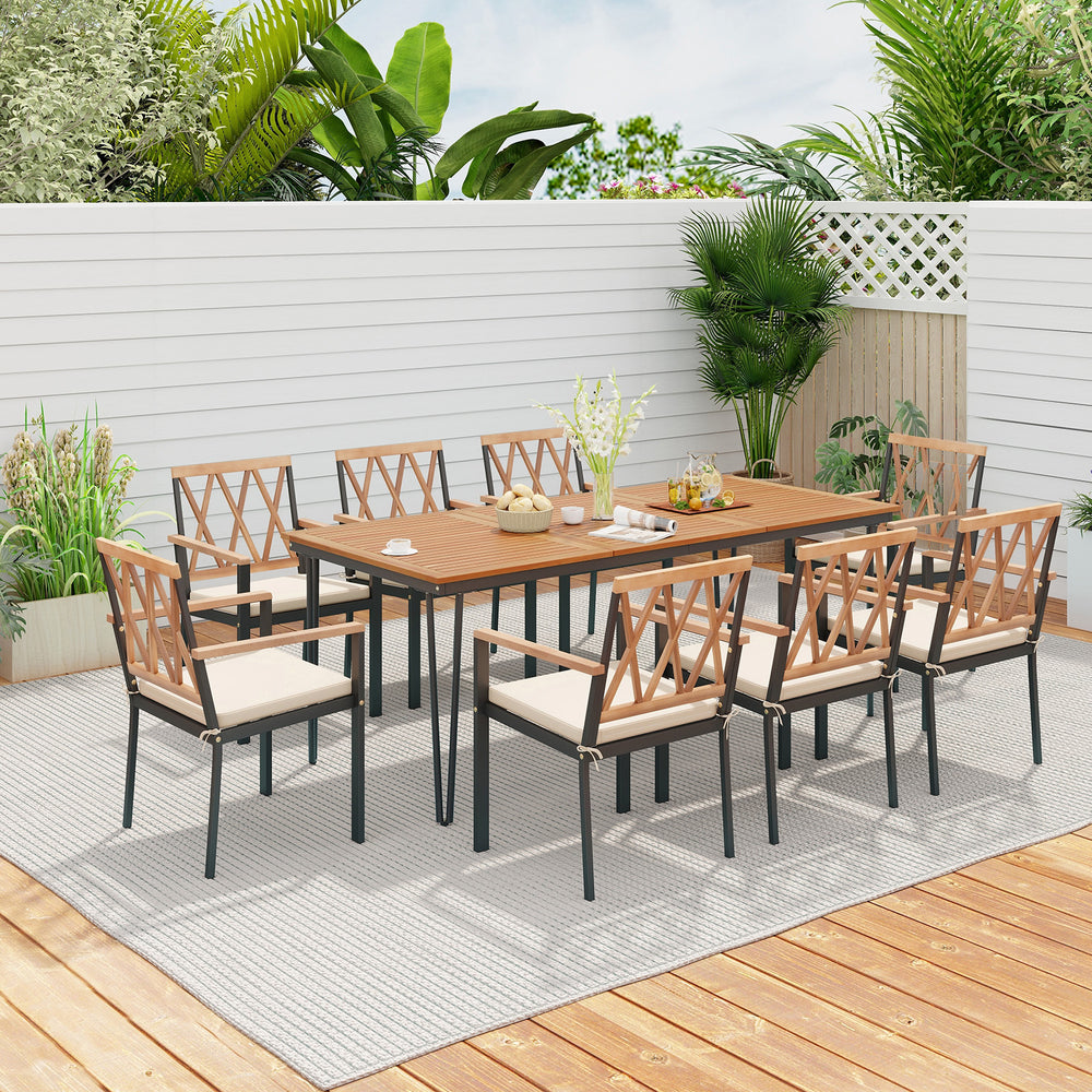 Full view of a 9-piece patio dining set on a wooden deck, showcasing the elegant acacia wood table and cushioned chairs.