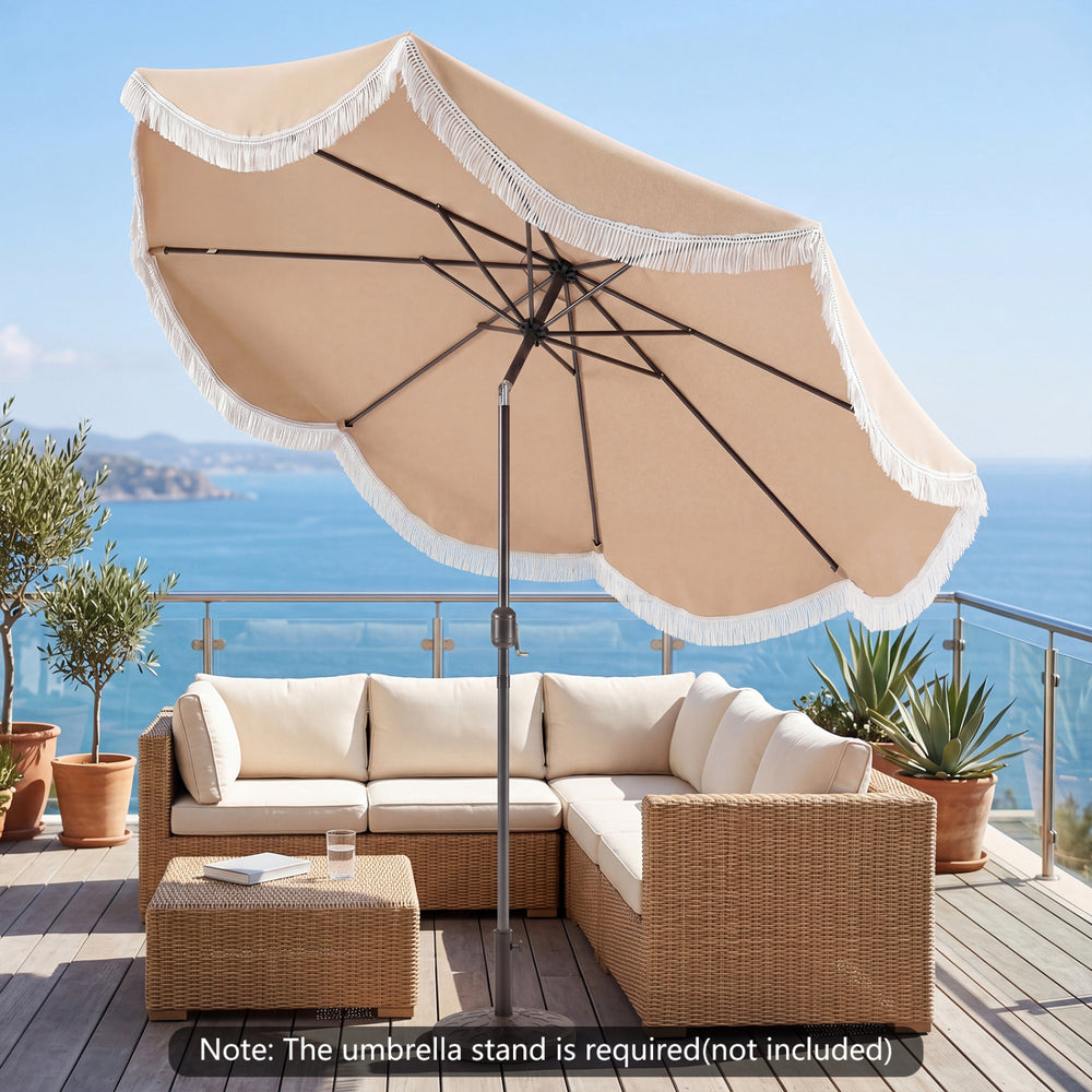 Outdoor tassel umbrella with push button tilt in white, providing shade for patio seating area with ocean view.