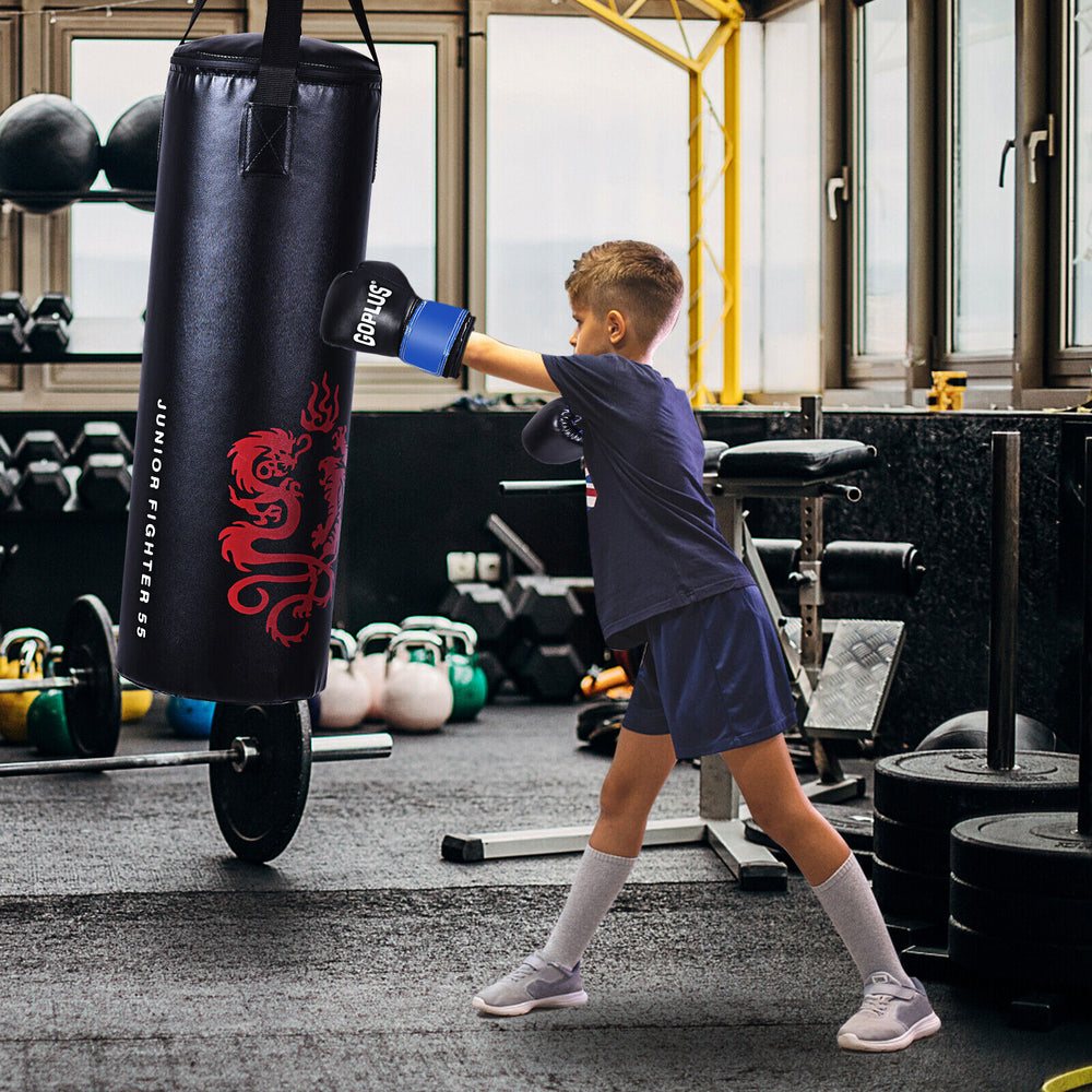 Child practicing boxing with a filled punching bag, featuring gloves and a sturdy PU design for durability.