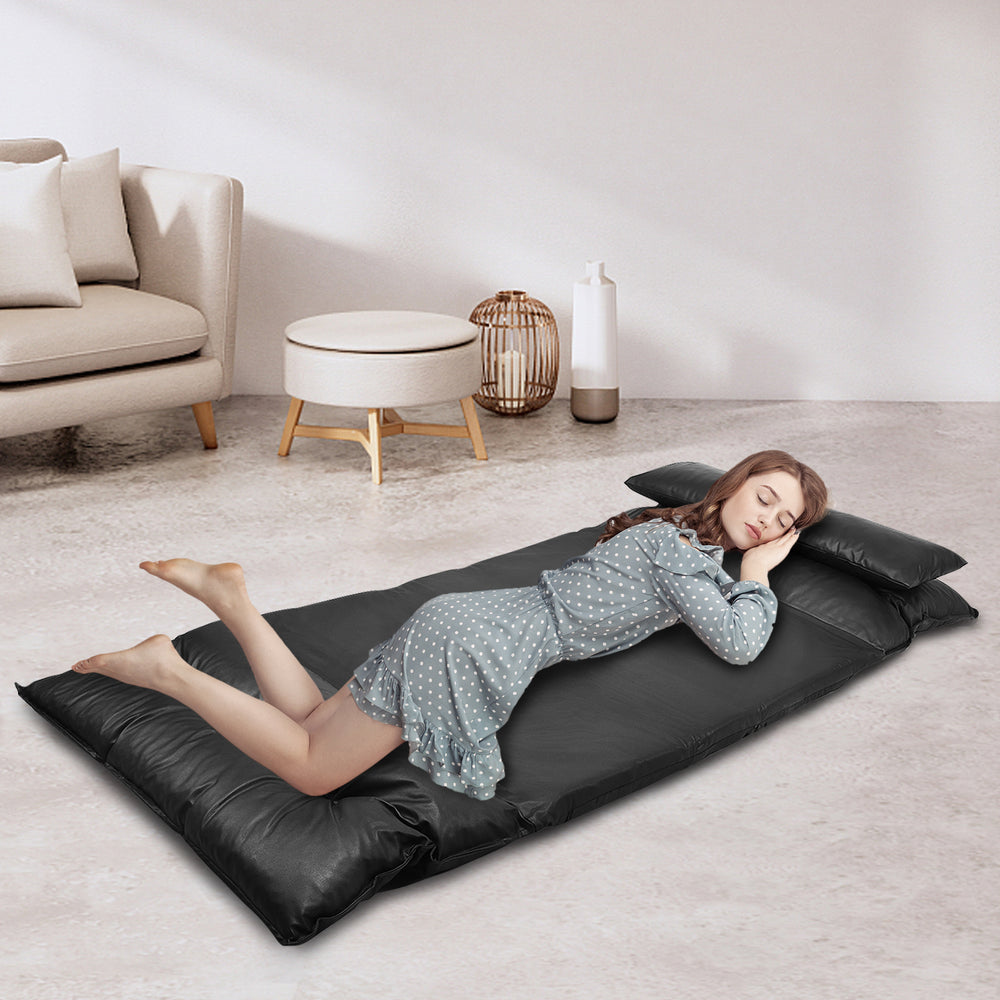 Foldable black PU leather leisure floor sofa bed with two pillows, adjustable for lounging, reading, or relaxing.