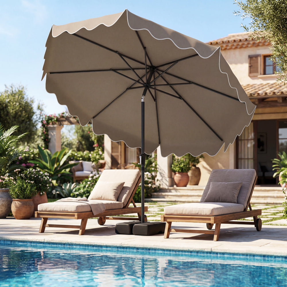 Patio umbrella with ruffled edges and weighted base, providing shade for outdoor relaxation by the pool.