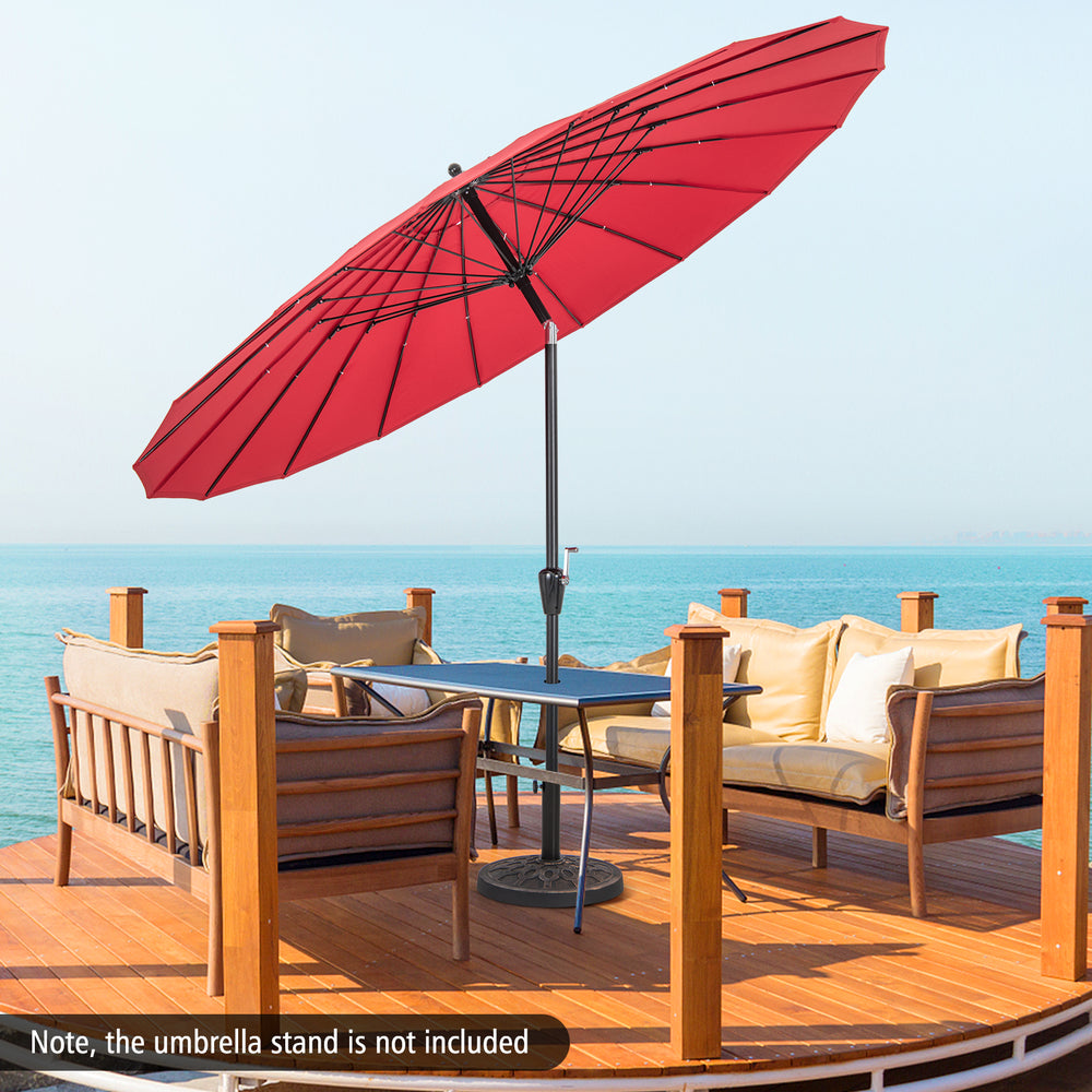 9-foot round patio umbrella in wine color with fiberglass ribs, tilted for sun protection on a deck by the water.