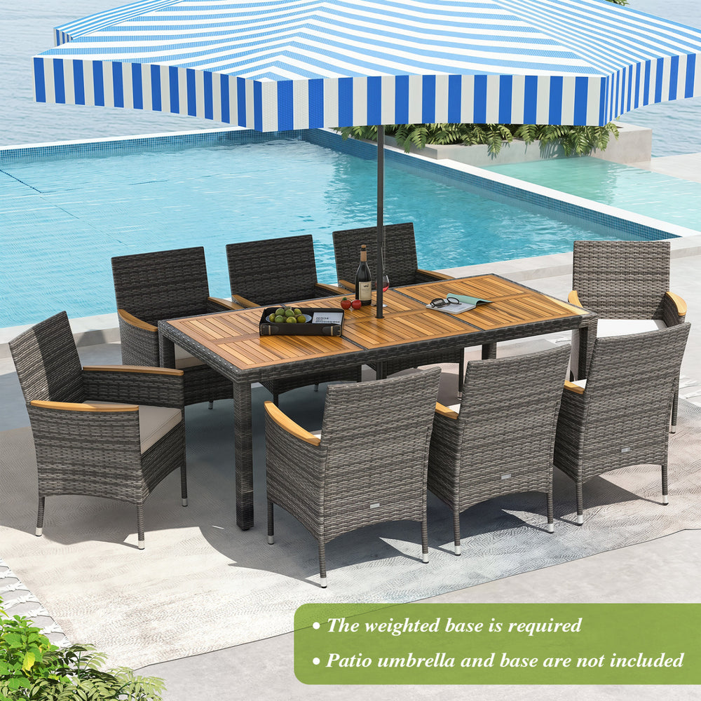 9-piece rattan patio dining set featuring an acacia wood table and cushioned chairs, ideal for outdoor dining.