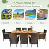9 pieces rattan dining set featuring an acacia wood table and stackable cushioned chairs, ideal for outdoor gatherings.