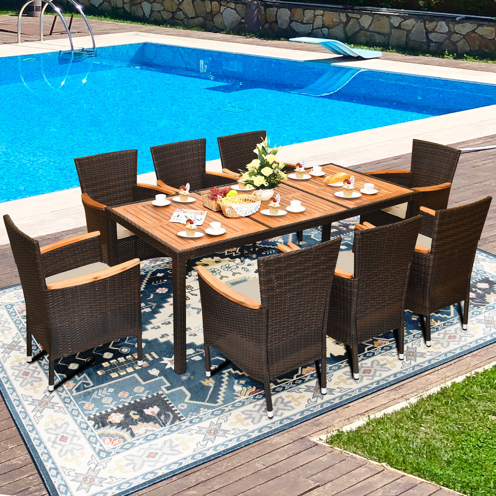 9-piece rattan dining set featuring an acacia wood table and stackable cushioned chairs, ideal for outdoor gatherings.
