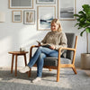 Accent chair with gray corduroy upholstery, lumbar pillow, and solid wood frame, ideal for cozy reading spaces.