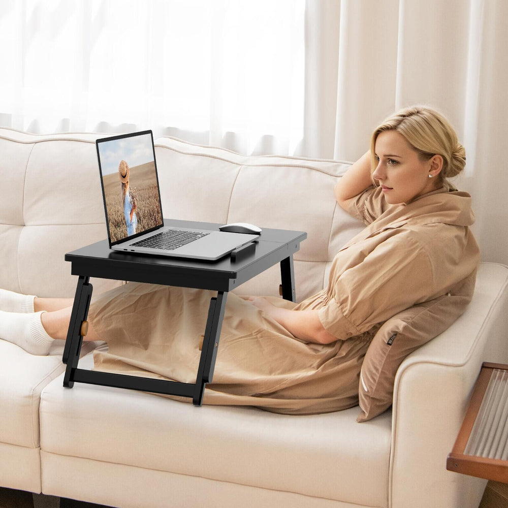 Adjustable bamboo laptop desk with tilting top, featuring a drawer, ideal for cozy work or study in any room.
