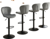 Set of 4 adjustable counter height chairs with gray velvet upholstery and 360° swivel design for modern dining spaces.