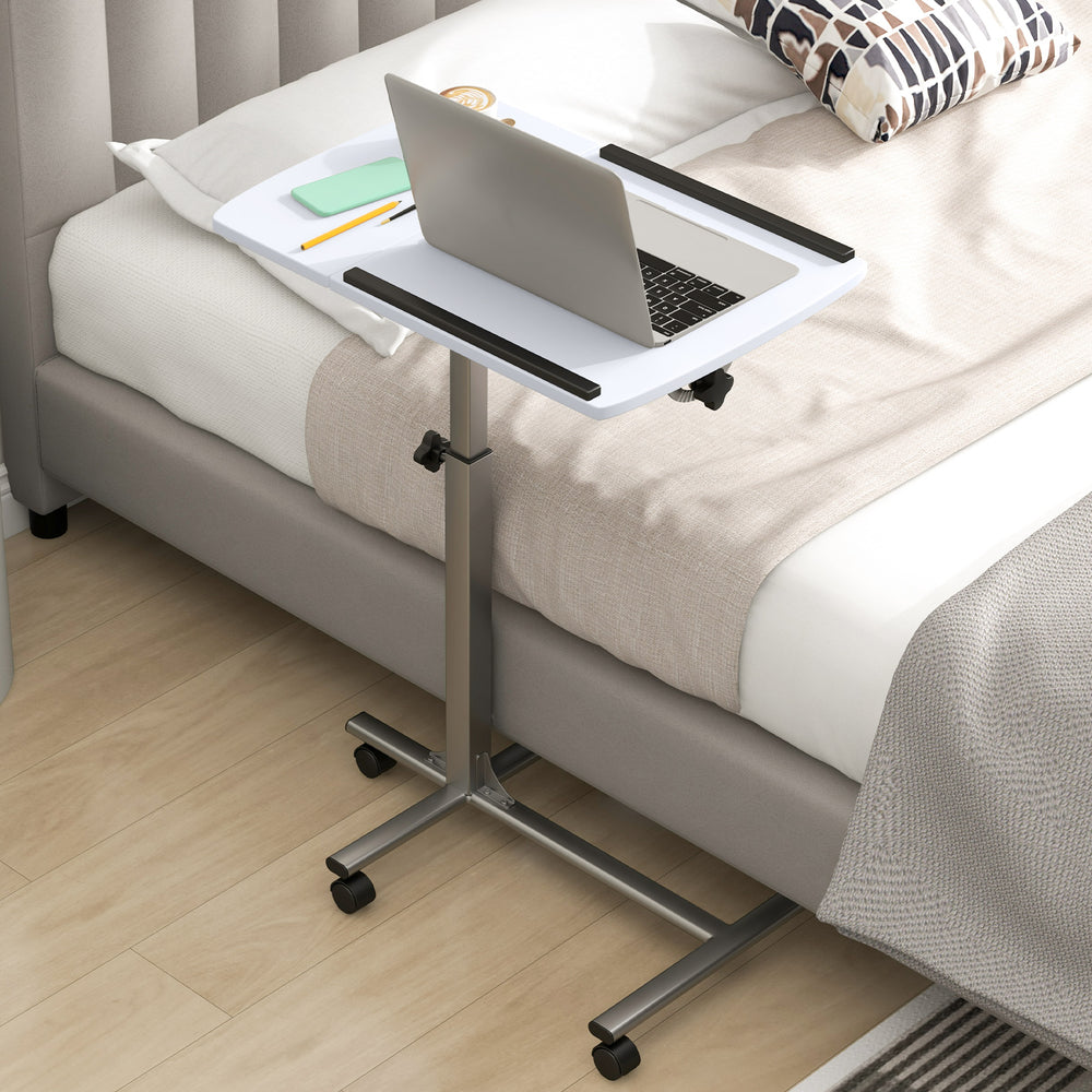 Adjustable height rolling laptop table in white with a sturdy steel frame, ideal for bedside use and flexible.