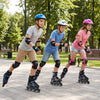 Three kids roller skating in a park wearing adjustable blue inline skates with illuminating wheels for safety.