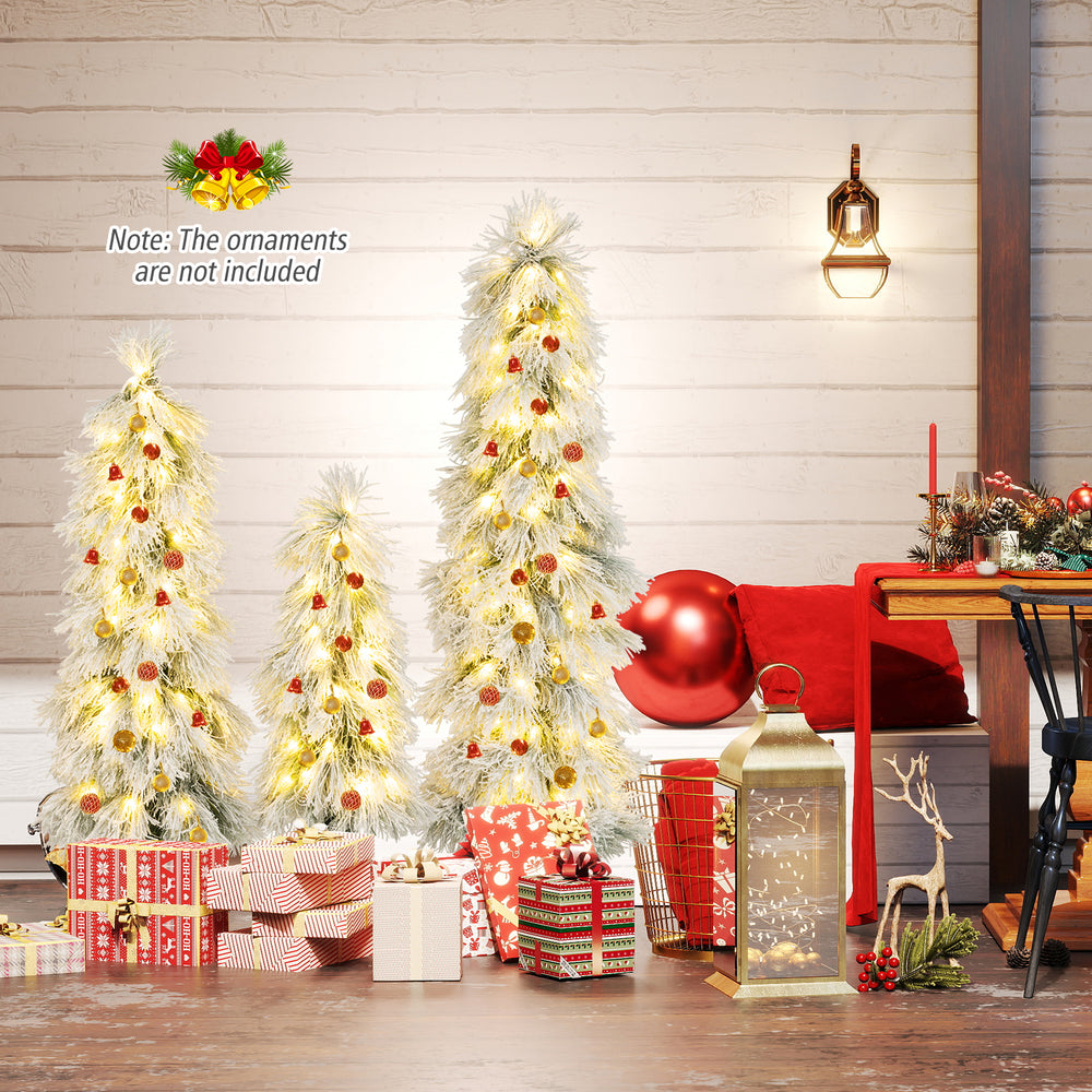 Three artificial Christmas trees with snow-flocked tips and warm white LED lights, perfect for festive holiday decor.