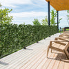 Artificial lily leaf privacy fence on a wooden deck, providing a decorative backdrop for outdoor spaces.
