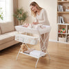 Foldable beige diaper changing table with side basket, bottom shelf, and safety features for easy baby care.