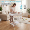 Foldable beige diaper changing table with side basket, height ruler, and safety features for effortless diaper changes.