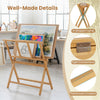 Bamboo art print rack with X-shaped frame and middle shelf for displaying and organizing canvases and artwork.