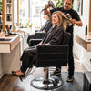 Black barber salon chair featuring a hydraulic pump, 360° swivel, and ergonomic design for client comfort.