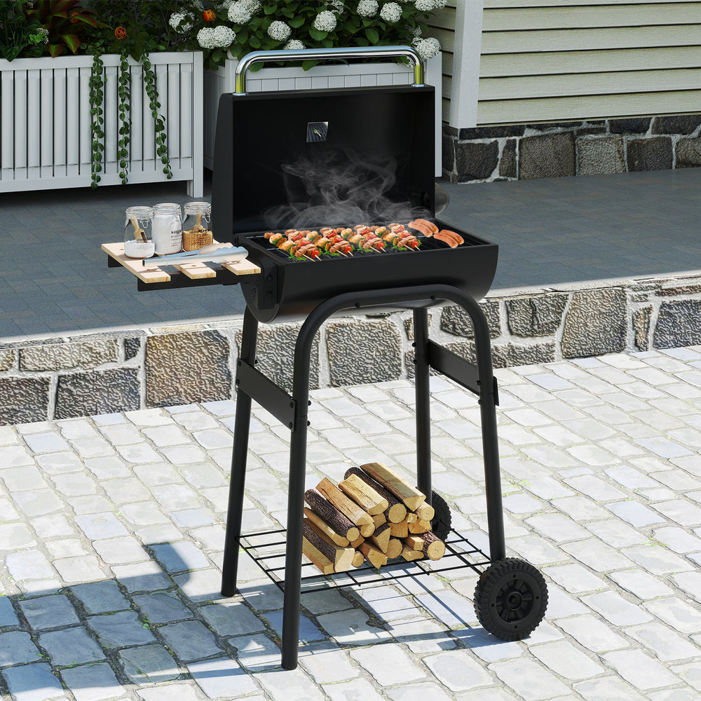 Barrel charcoal grill with foldable side table, built-in thermostat, and storage shelf, perfect for outdoor cooking.