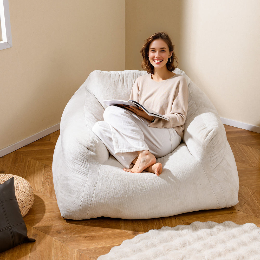Plush beige bean bag chair with ergonomic support, perfect for relaxing, reading, or watching TV in comfort.