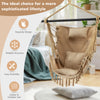 Hanging rope swing chair in beige with soft pillow and cushions, featuring elegant tassels for indoor and outdoor use.