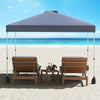 Gray 10x10 ft pop-up canopy tent with sidewall, set up on the beach with two lounge chairs for sun protection.