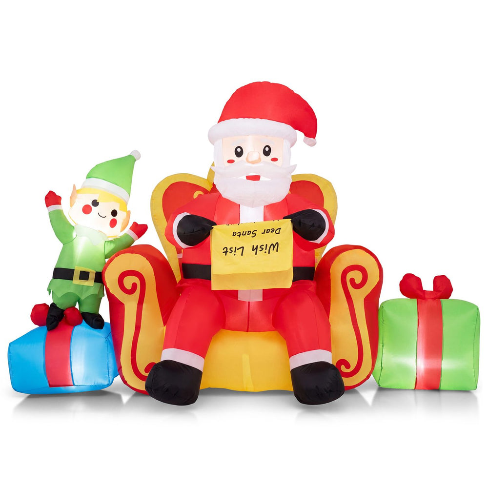 Inflatable Santa Claus with elf and gift boxes on a sofa, designed for cheerful holiday decorating in outdoor spaces.