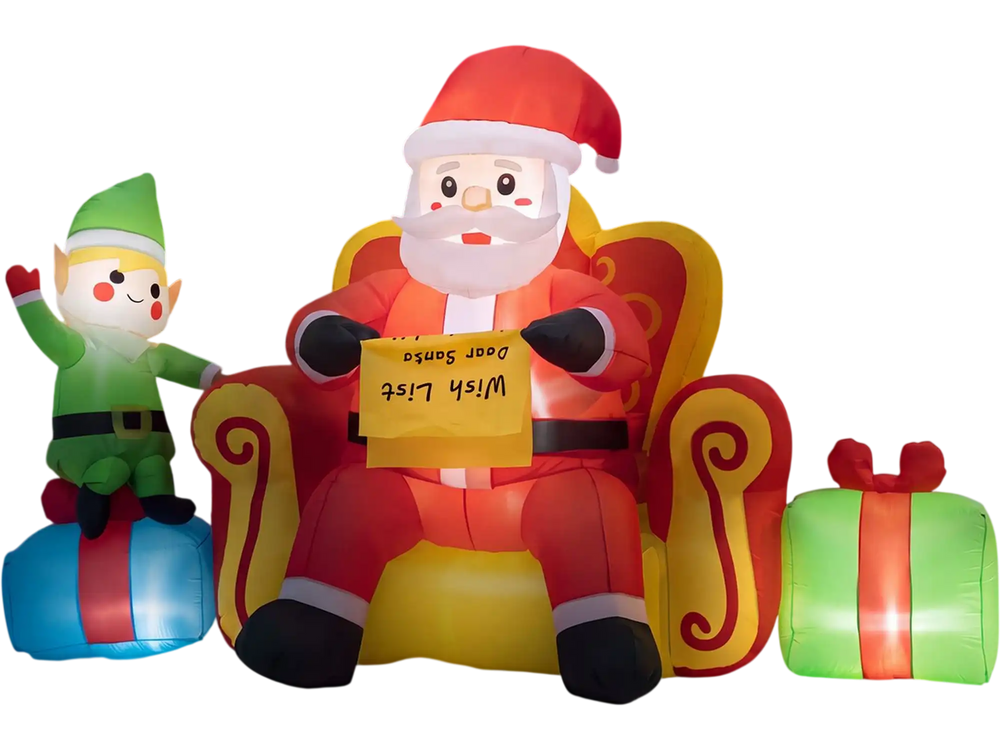 Christmas inflatable elf beside Santa Claus on sofa with colorful gift boxes, ideal for charming holiday displays.