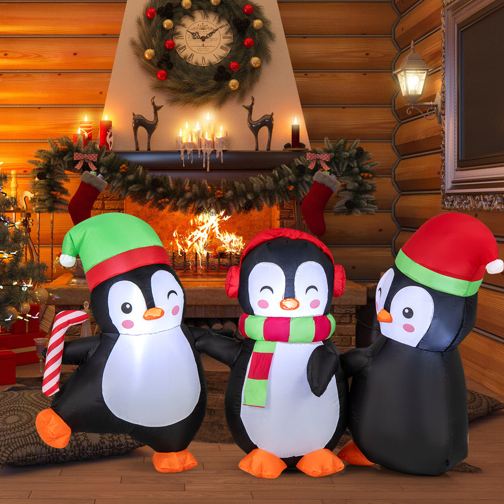Inflatable Christmas penguin family with LED lights, Santa hats, and candy cane for festive indoor or outdoor display.