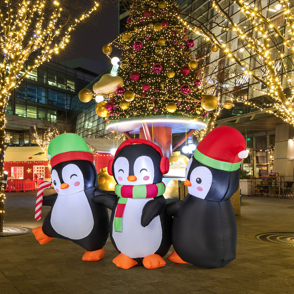 Three inflatable Christmas penguins with LED lights, wearing Santa hats and a scarf, perfect for festive outdoor.
