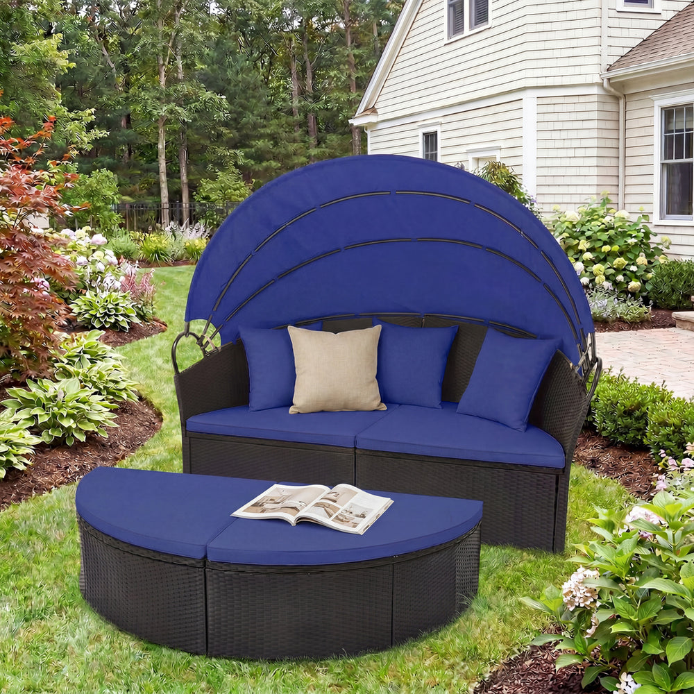 Clamshell patio round daybed in blue wicker with retractable canopy and pillows, perfect for outdoor relaxation.