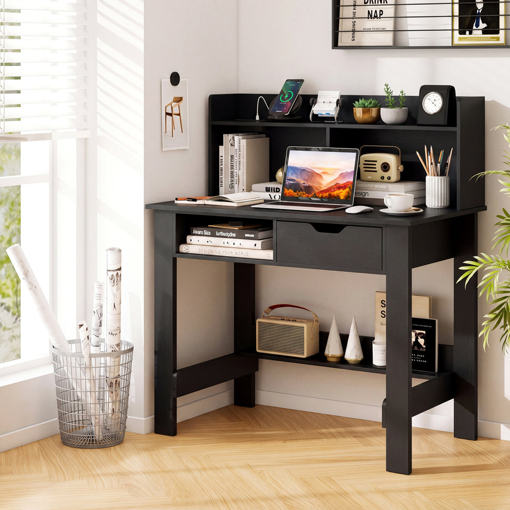 Black computer desk with a wide surface and open hutch for efficient workspace organization in a modern setting.