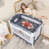 Convertible bassinet in grey with removable changing table, featuring mesh sides and a baby lying comfortably inside.