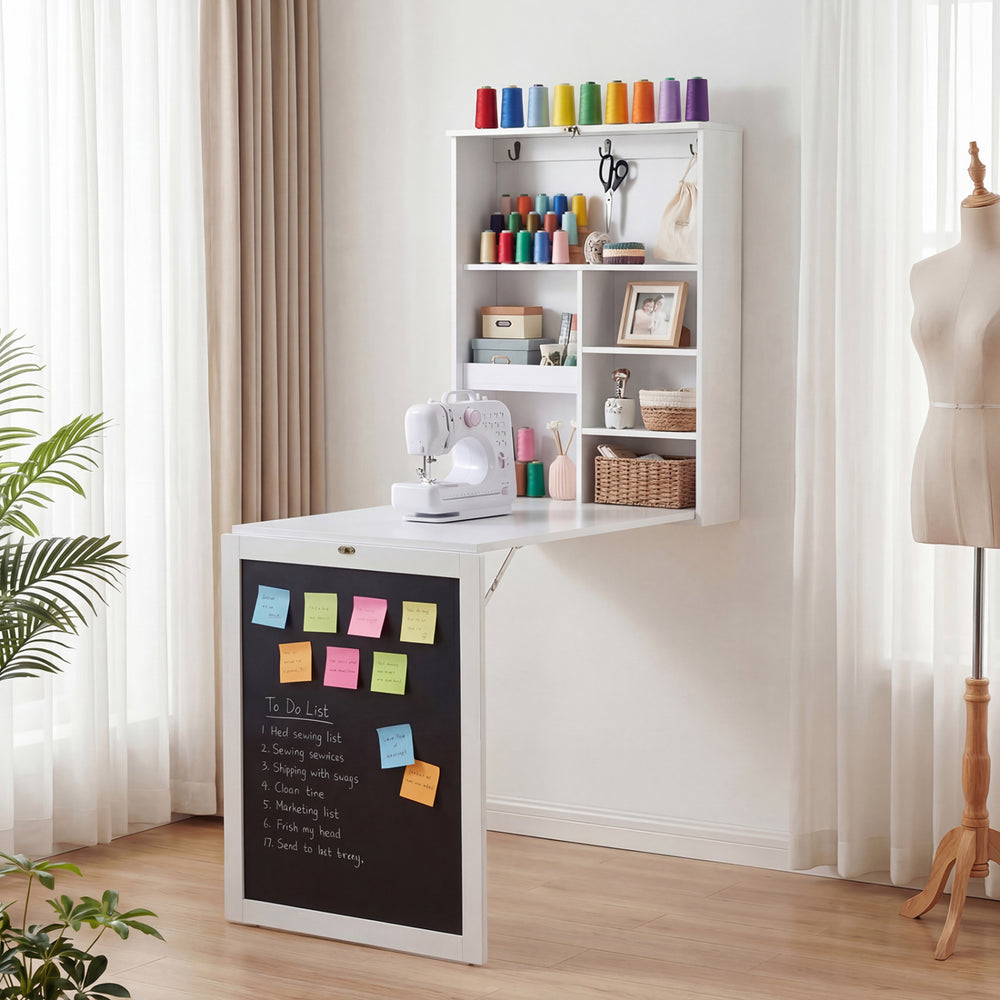 Convertible wall-mounted table in white with a chalkboard, providing a stylish, space-saving workspace and storage.