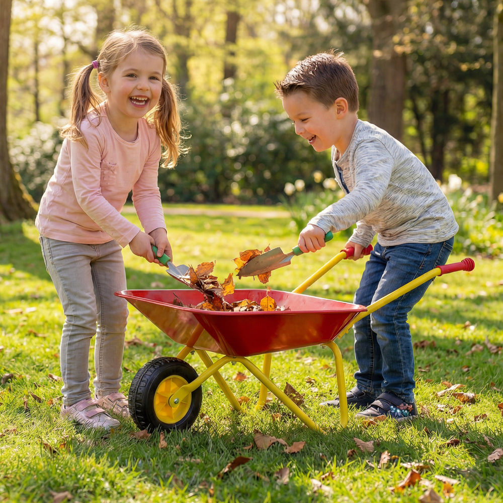 Kids wheelbarrow in red with all-terrain wheels, perfect for hauling toys and leaves, shown in use by two children.