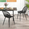 Black modern kitchen chairs with cutout backrest and metal legs, ideal for dining rooms and home offices.