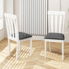 Two white dining chairs with padded seats and slat backs, ideal for kitchen or dining room use.
