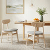Two natural rubber wood dining chairs with fabric upholstery, featuring ergonomic backrests, in a cozy kitchen setting.