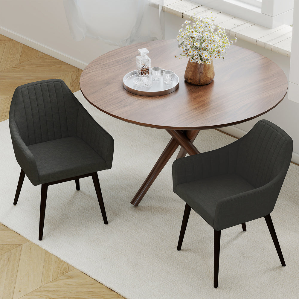 Two black upholstered dining chairs with padded backrests and rubber wood legs, perfect for dining rooms or cafes.