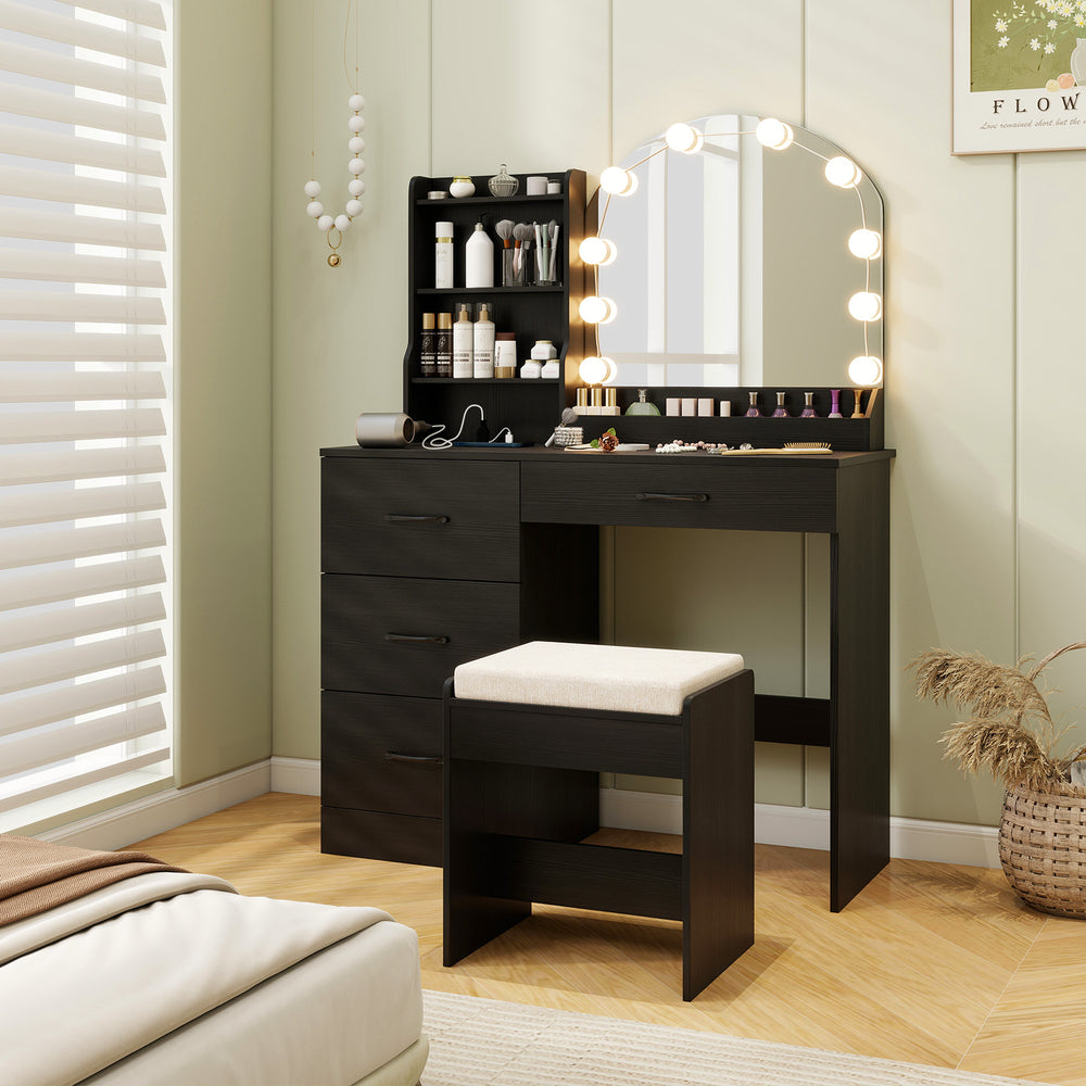Black makeup vanity desk with three-color LED mirror, ample storage, and a matching stool for a chic dressing area.