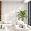 White 3D decorative PVC ceiling tiles in a modern living room, showcasing a stylish wall installation.
