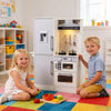 Dual-sided kids play kitchen in white with water dispenser, range hood, and cooking utensils for imaginative play.