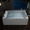 A modern white 71 in. Freestanding Combination Massage 2-Person LED Tub with Center Drain by Empava, filled with water and light bubbles, stands in a dimly lit bathroom with dark walls and a wooden floor. The tub features built-in armrests and a sleek digital control panel on its side, perfect for enjoying Revi-Skin Therapy. Nearby, a large window and potted plant are visible.
