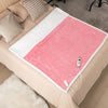 Electric heated blanket throw in pink with sherpa fleece, featuring 10 heat settings for cozy comfort on a bed.