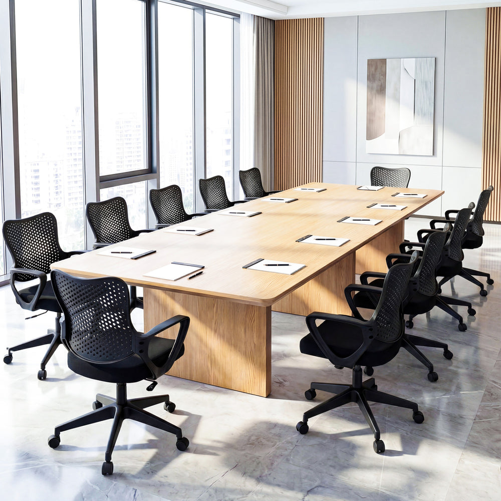 Height adjustable ergonomic office chairs with breathable butterfly backs around a large conference table in a modern.