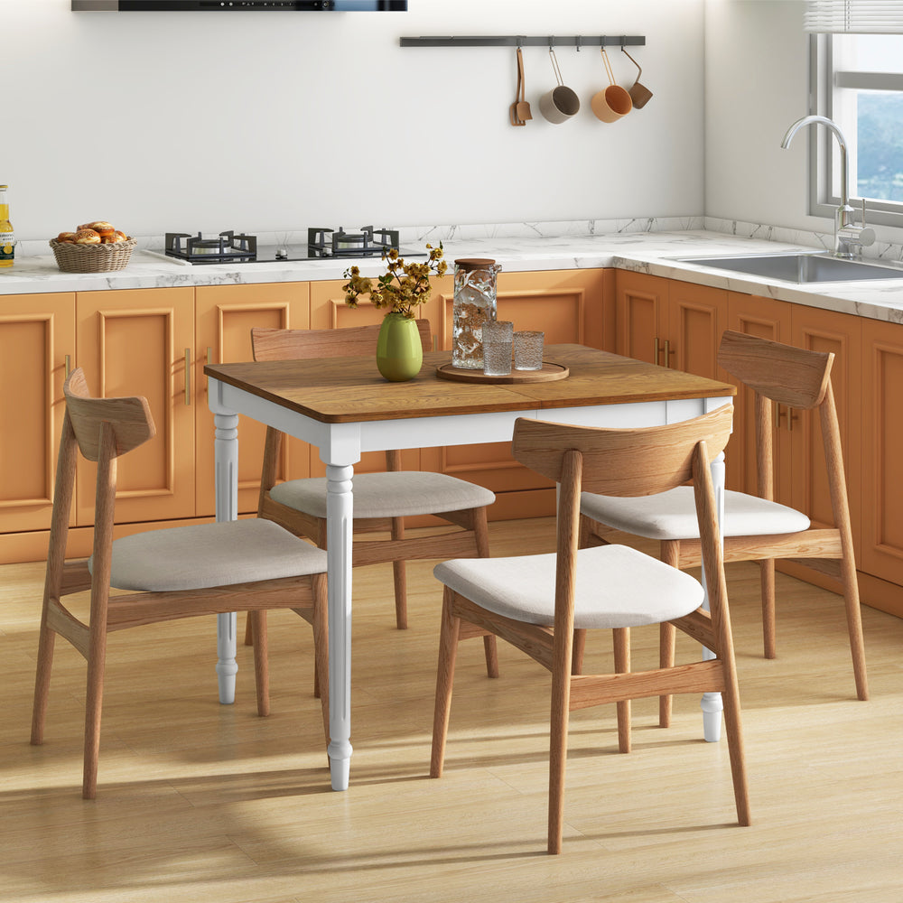 Extendable dining table with rubber wood legs, accommodating 4-8 people, set in a modern kitchen with orange cabinetry.
