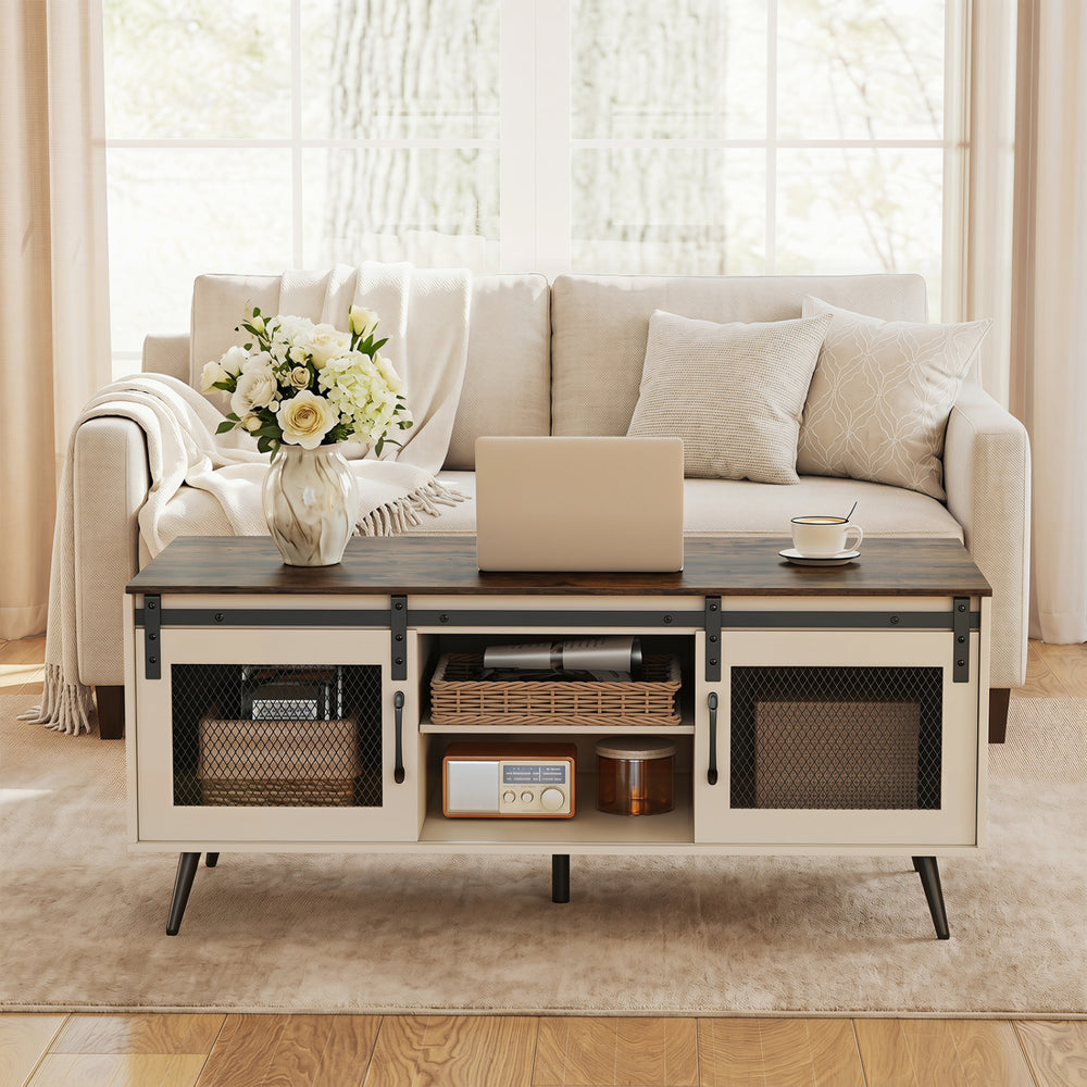 Farmhouse coffee table with sliding doors, rustic brown finish, adjustable shelf, and spacious cabinets for storage.