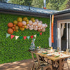 Artificial greenery foliage panels displayed on a wall, featuring 6 plant types for customizable outdoor decor.