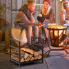 Firewood log rack in black with raised feet and handles, holding logs for easy access by the cozy fire pit.